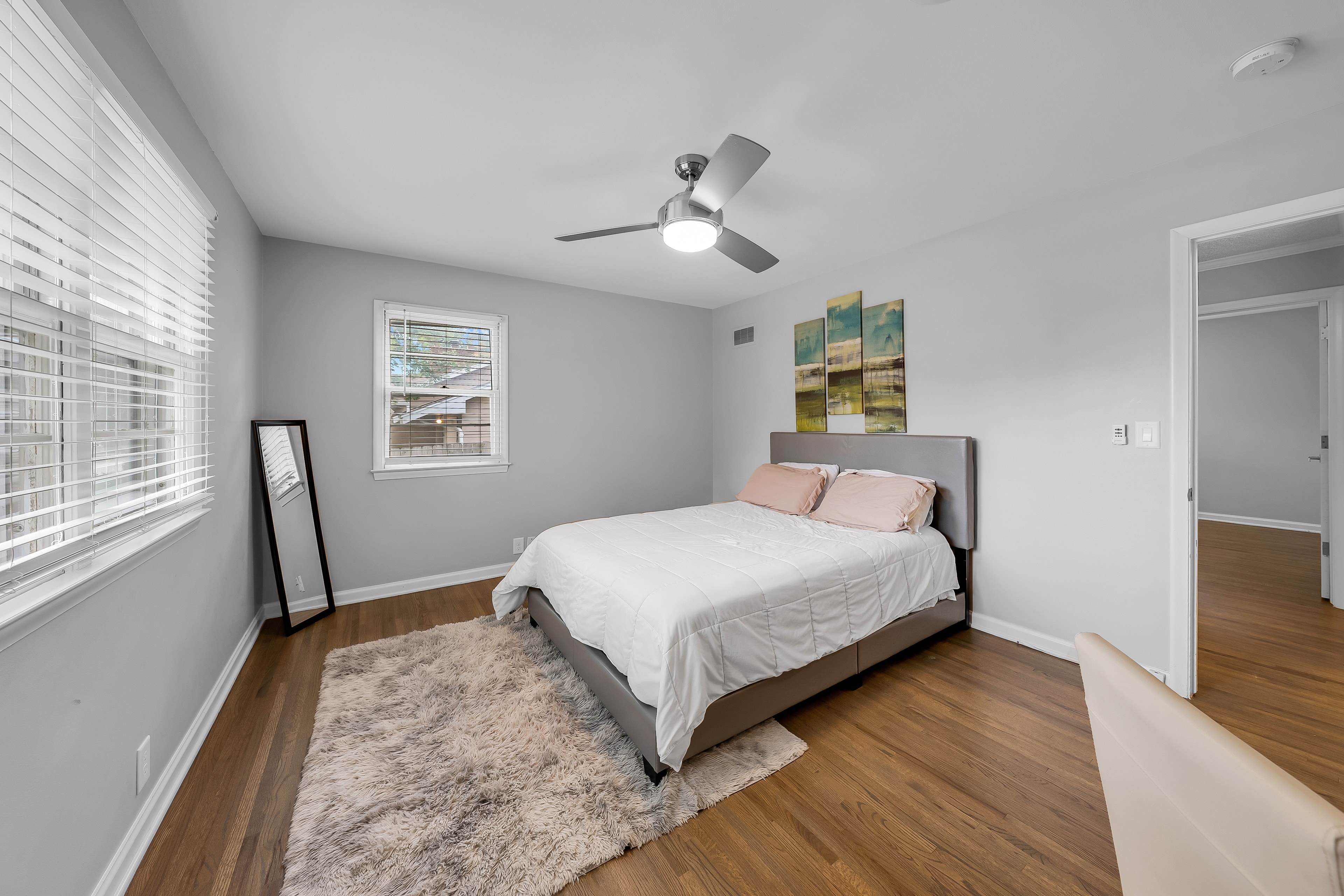 RCVRY HOUSE master bedroom with ceiling fan, hardwood floors, and walk-in closet