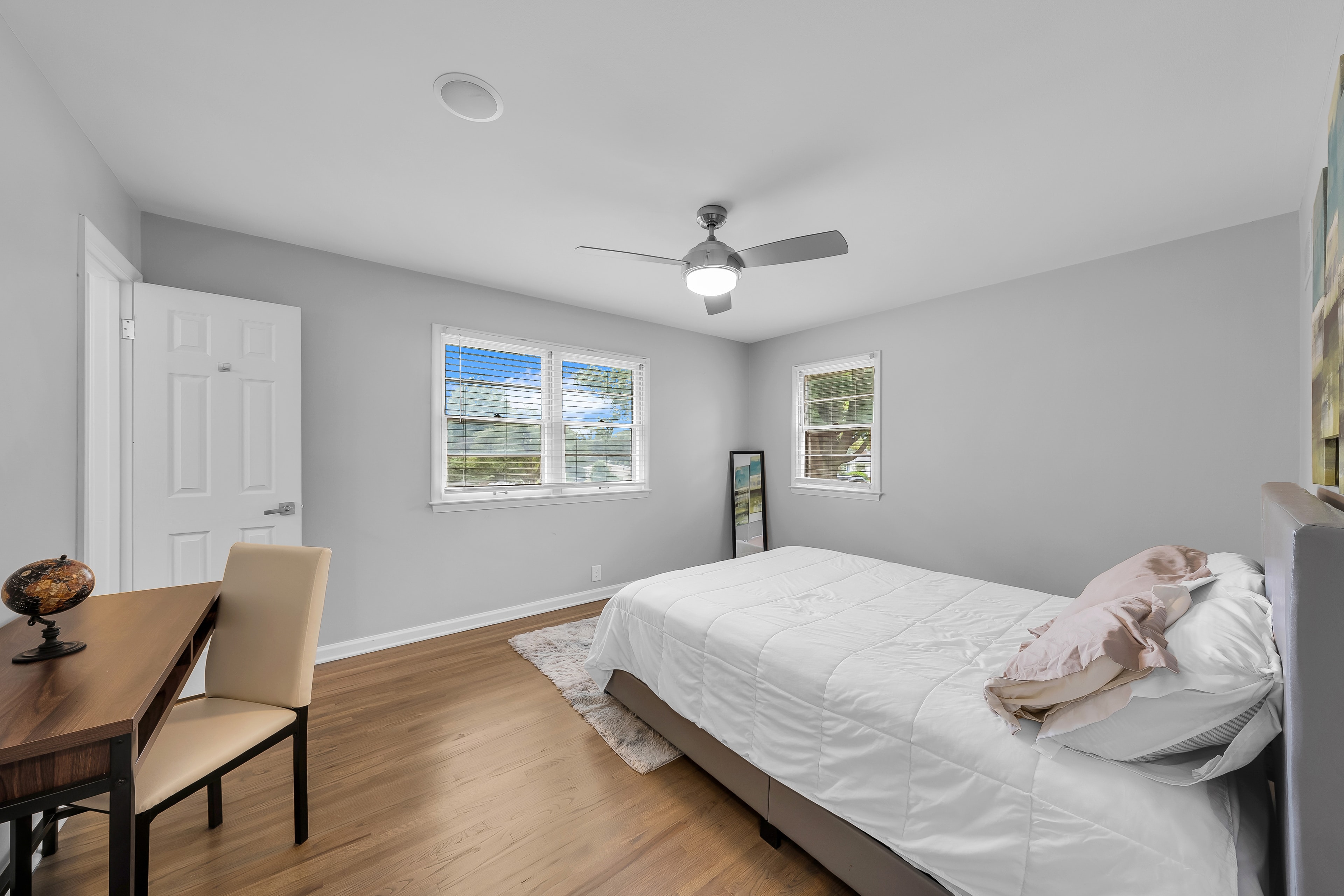 RCVRY HOUSE master bedroom with desk, chair, and two windows