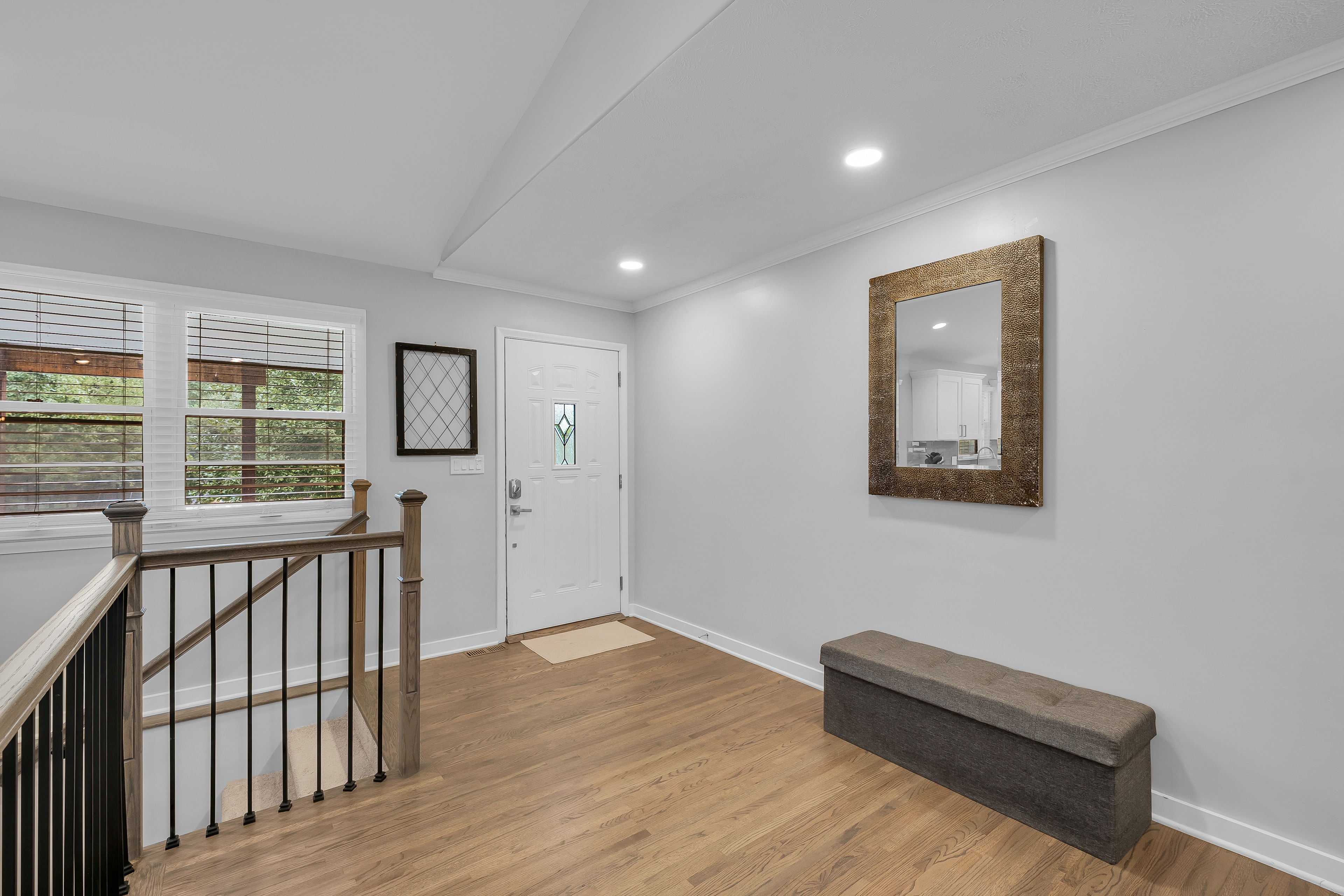 RCVRY HOUSE entry foyer with front door, staircase, and bench