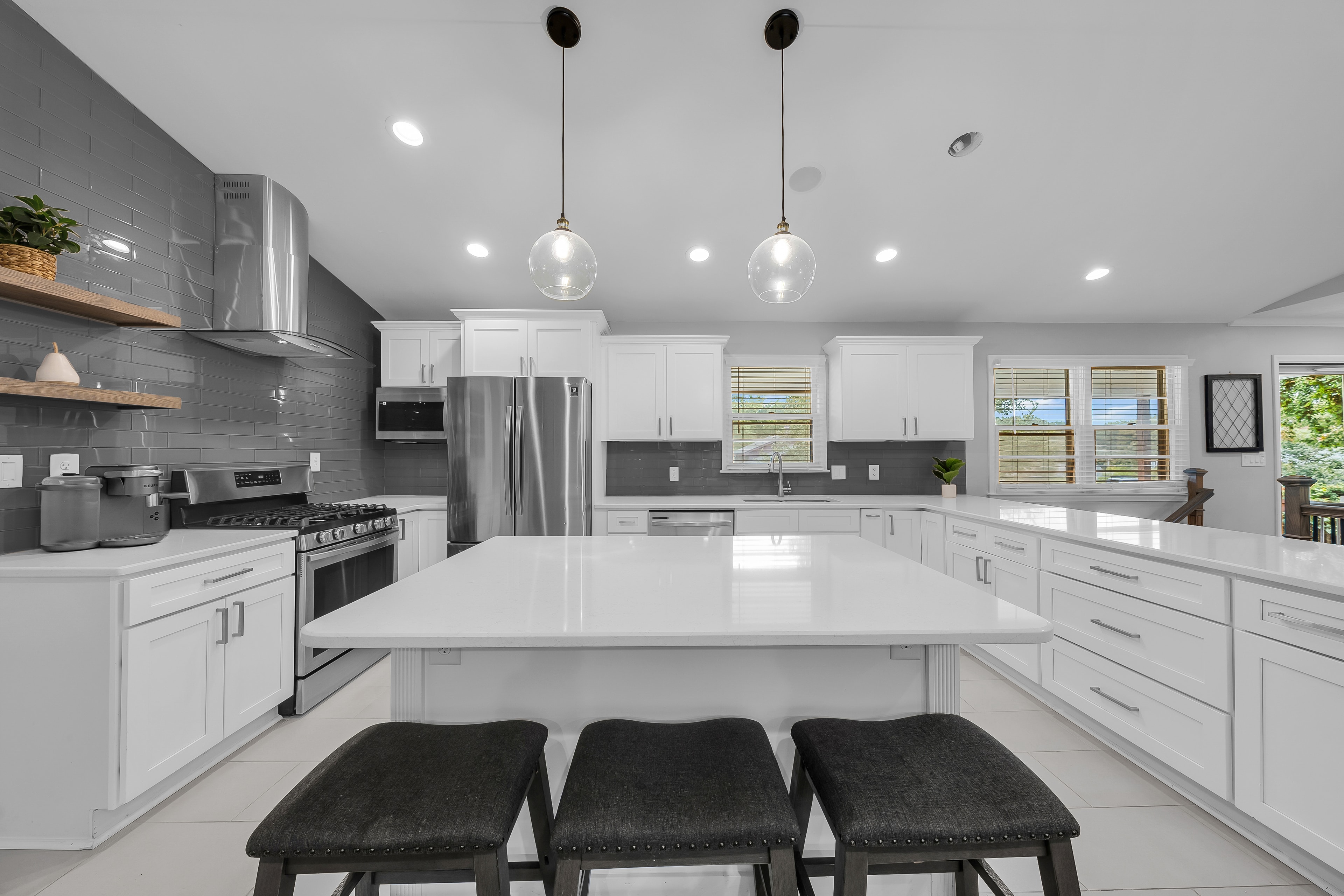 RCVRY HOUSE kitchen island straight-on with bar stools and appliance wall