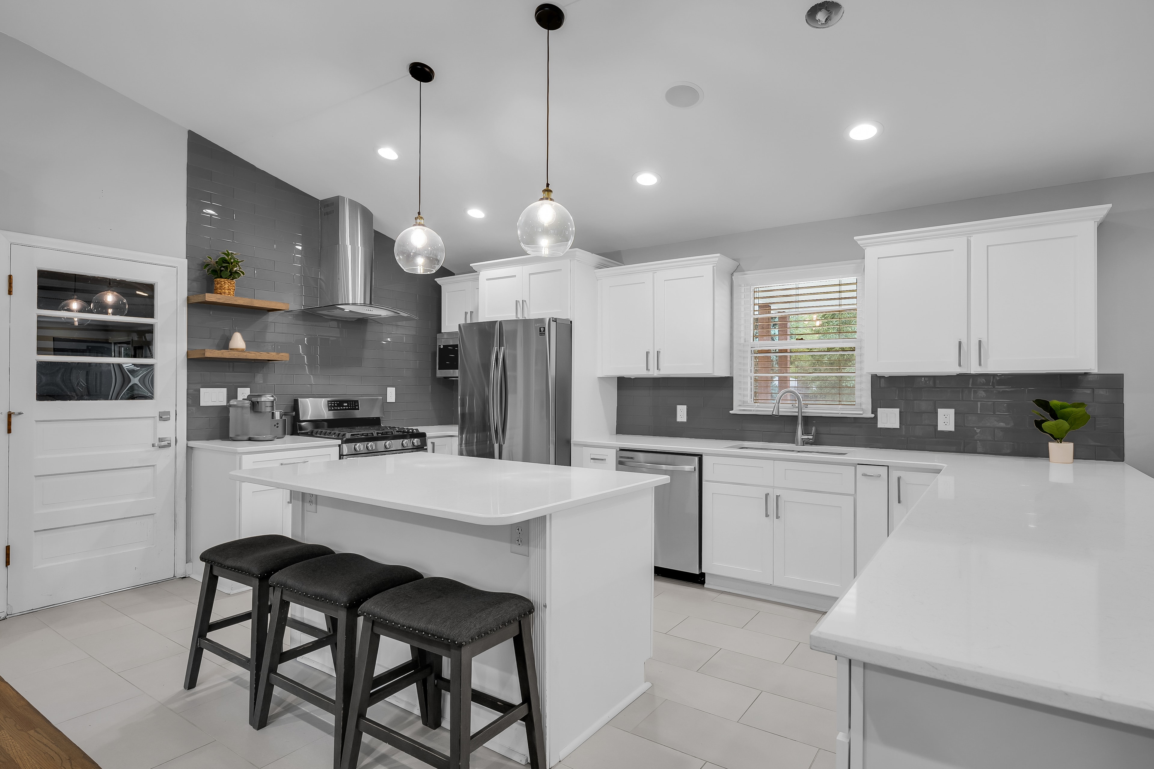 RCVRY HOUSE kitchen island with pendant lights and stainless appliances