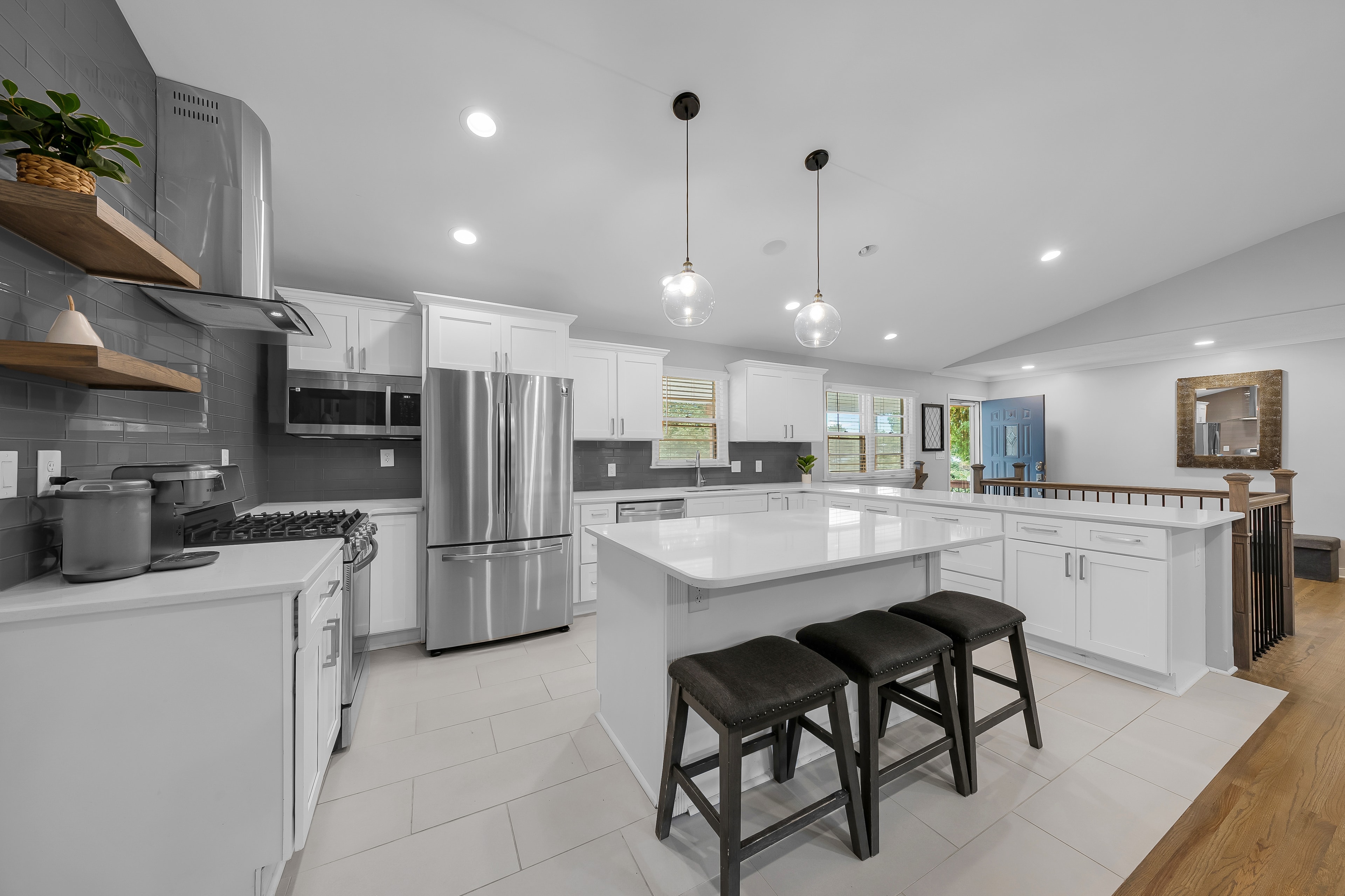 RCVRY HOUSE kitchen island with staircase railing in background