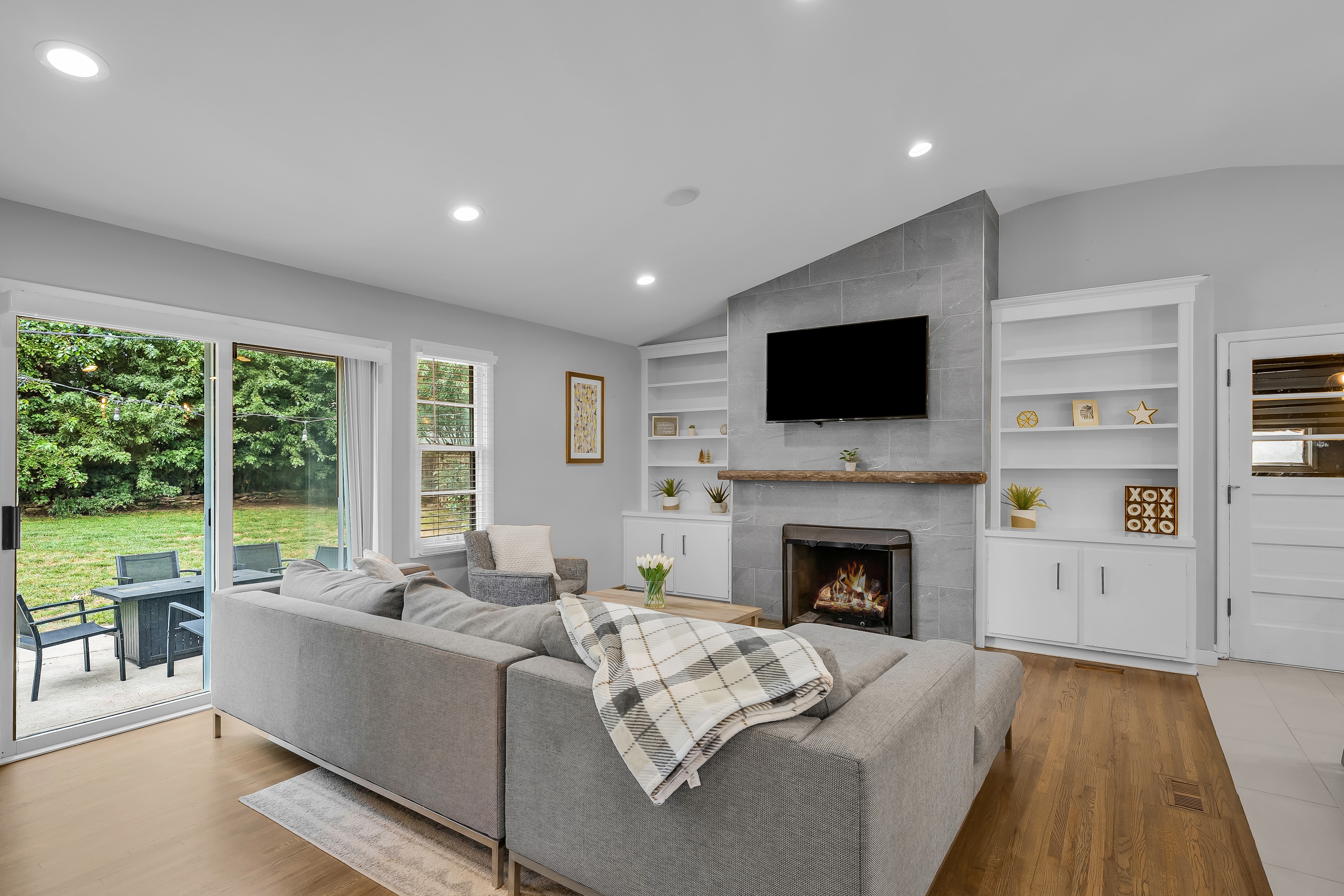 RCVRY HOUSE living room fireplace with backyard view through sliding doors