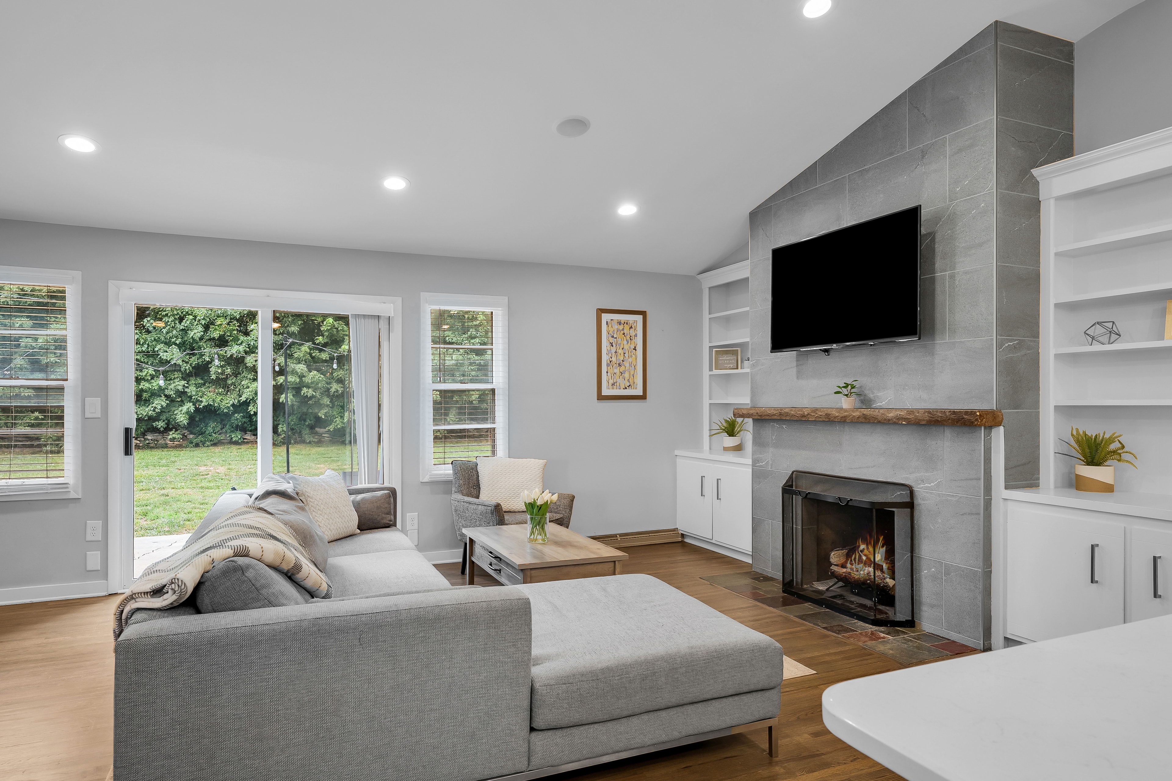 RCVRY HOUSE living room with fireplace, built-in shelves, and Smart TV