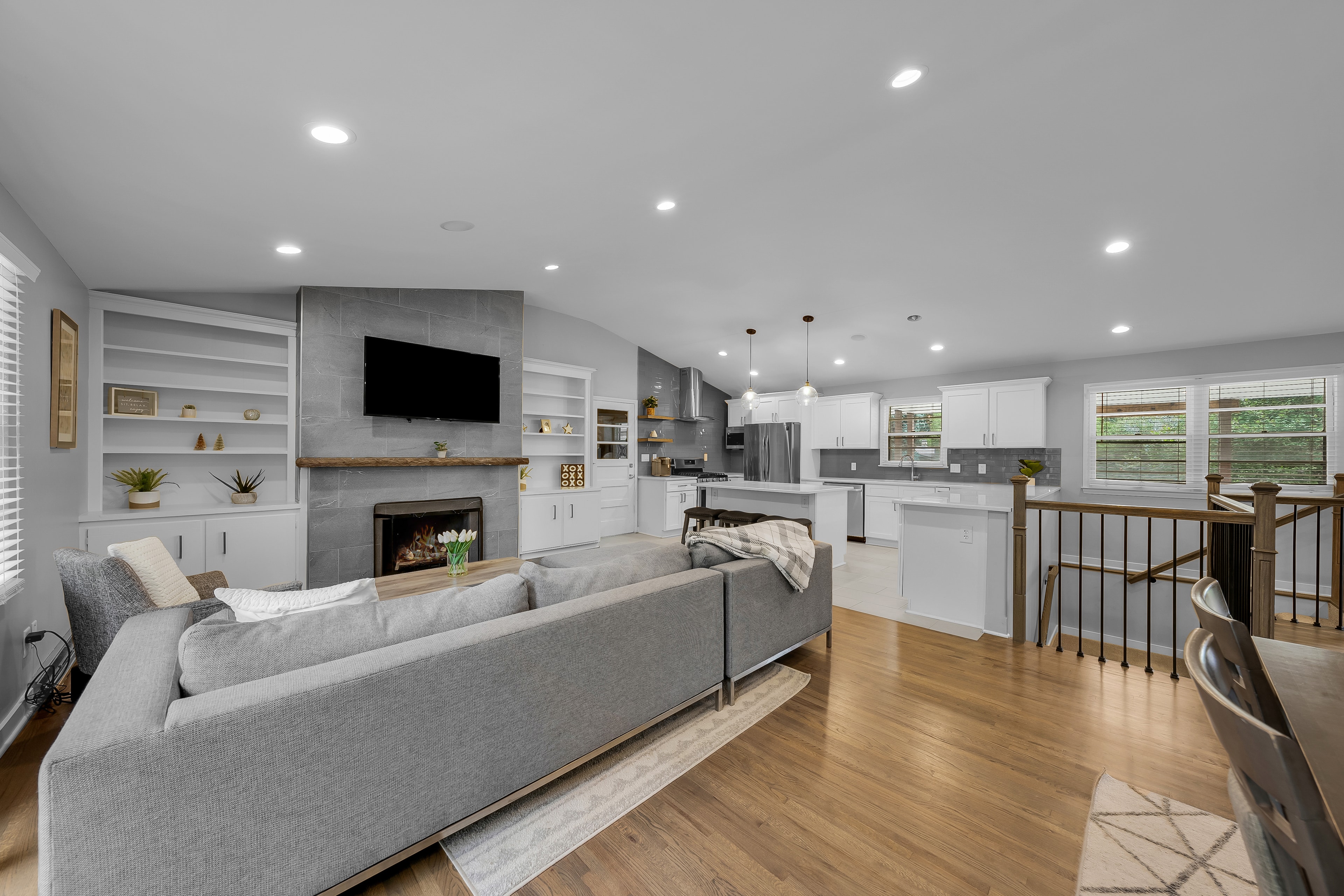 RCVRY HOUSE living room and kitchen from dining area with staircase railing