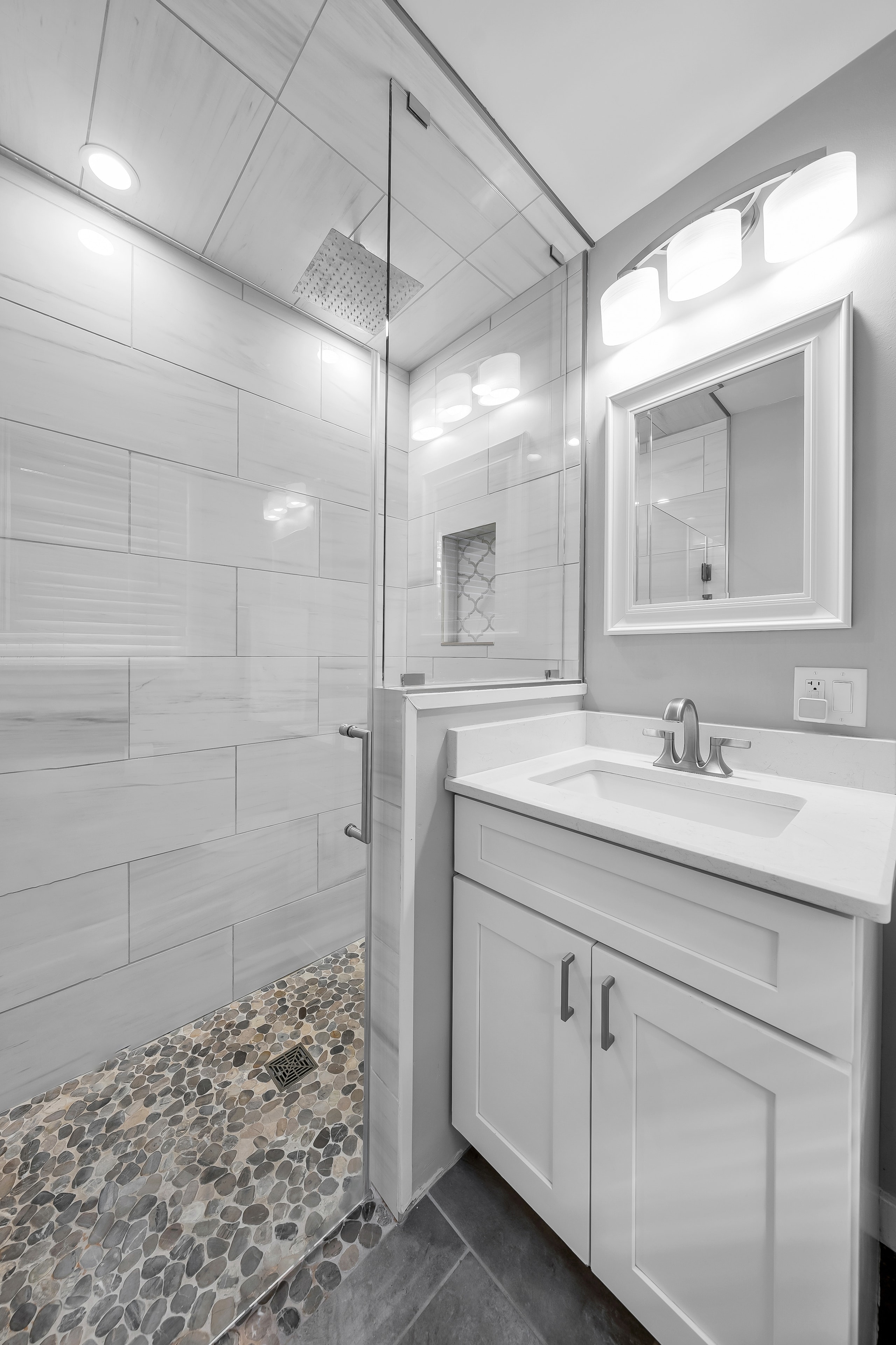 RCVRY HOUSE master shower with glass enclosure and pebble tile floor