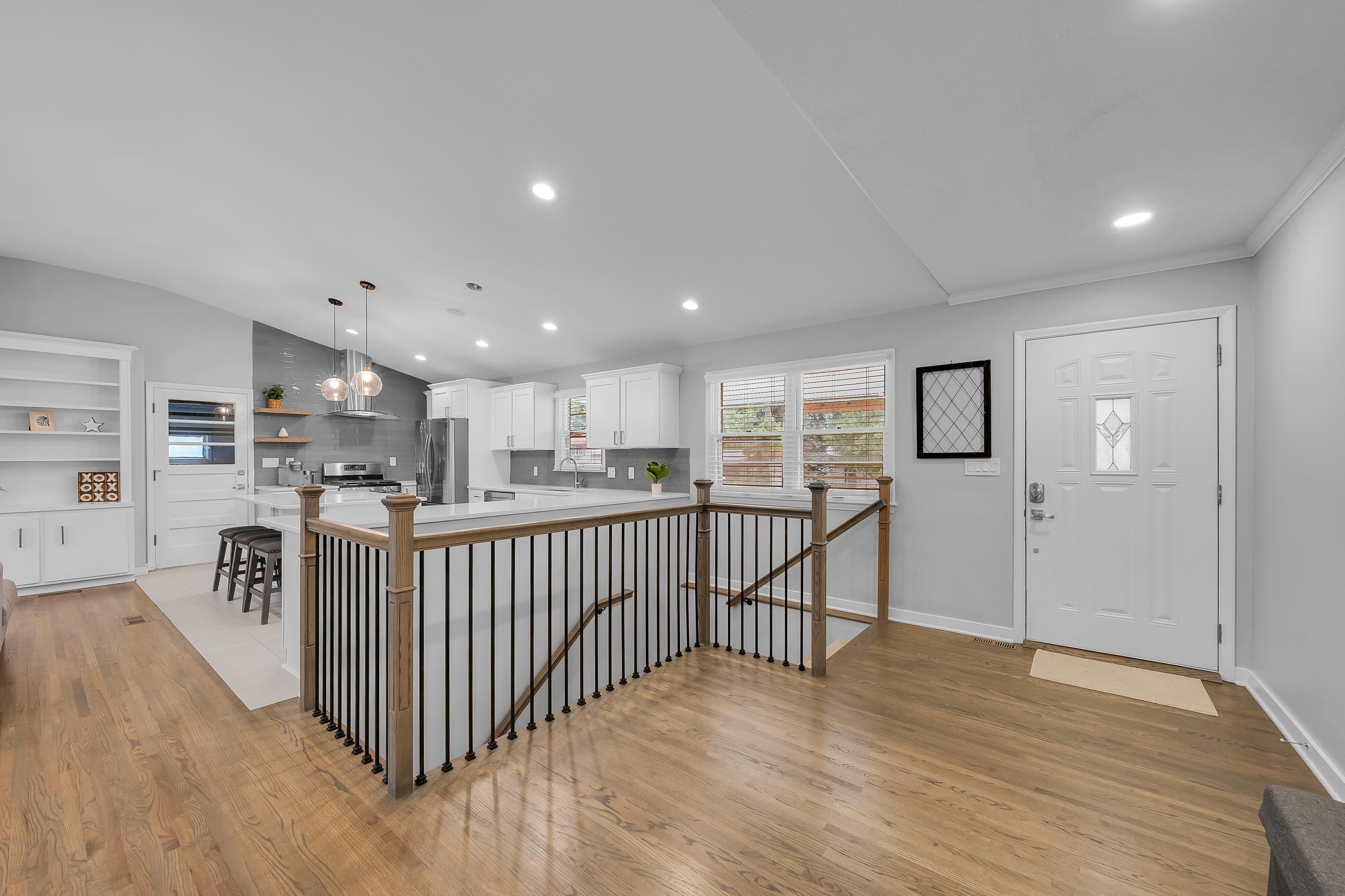 RCVRY HOUSE open floor plan from entry side — staircase, kitchen, and front door